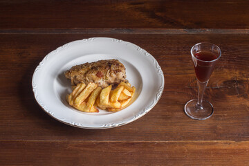 Plating food of chicken with potatoes and cognac on a wooden table. Cooking recipes at home. Meat, and vegetables.