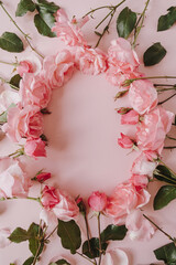 Valentine's Day / Mother's Day greeting card mockup. Frame wreath with empty blank copy space. Beautiful pink roses flowers on pink background. Flat lay, top view minimalistic floral composition.