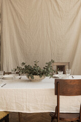Modern interior dinning room design with bohemian styled decorations. Dinner table, eucalyptus...