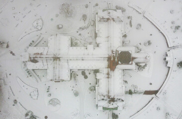 Top view of architectural building in the shape of a cross on a foggy winter evening