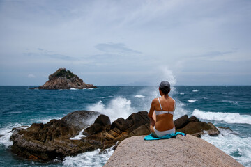 Fototapeta na wymiar Young woman watching the waves break