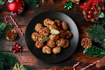 Obraz na płótnie Canvas Christmas Pork stuffing meatballs with sage and onion. decoration, gifts, green tree branch on wooden rustic table
