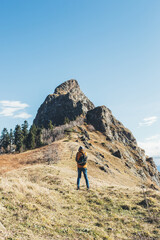 young male hiker with backpack on the background of the mountain peak