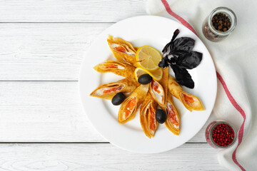 Russian pancakes stuffed with salted salmon on white wooden background