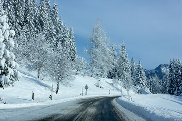 Fototapeta premium Icy road surrounded by a frozen landscape in the Alps (Filzmoos, Salzburg county, Austria)