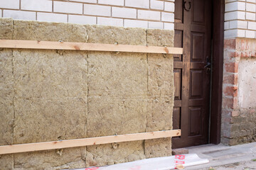 Insulation outdoor brick wall of the house with fiberglass.