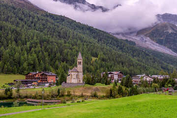 Fototapeta na wymiar View of Solda, South Tyrol, Italy, its parish church on the lake, with the Ortler mountains in the background