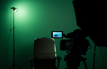 Green screen background and a black chair in a television Studio.