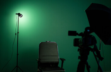 Green screen background and a black chair in a television Studio.