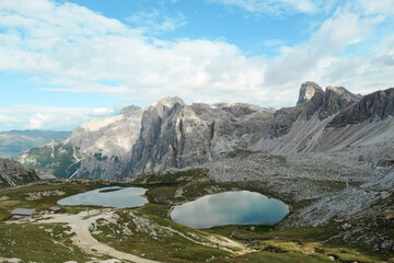 Small, navy blue lakes at the bottom of the valley in Italian Alps. The lakes are surrounded by...
