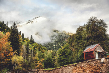 Little house on the cliff by the river in the Caucasus mountains