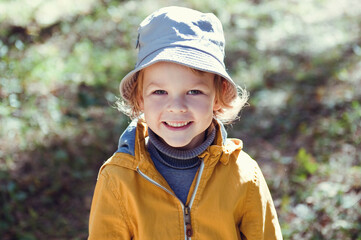 Portrait of a cheerful child in a yellow jacket.