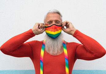Senior gay man wearing face protective mask celebrating gay pride event during corona virus pandemic