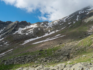 Fototapeta na wymiar Steep rocky path at mountain saddle at Stubai hiking trail, Stubai Hohenweg, Tyrol Alps, Austria, summer blue sky