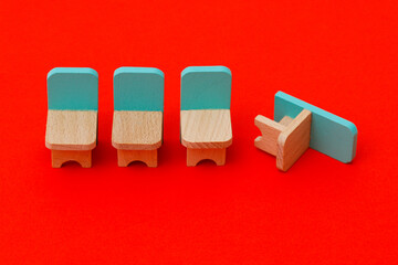 Four wooden toy chairs are in a row. The last chair fell