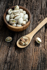 Pistachio nut in wooden bowl on rusty wood table background