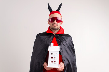 Adult caucasian man in halloween costume with decorative building in his hands isolated on white.