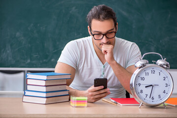 Young male teacher student sitting in the classroom