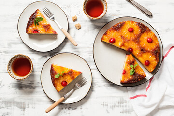 Homemade pineapple upside down pie with candied cranberry . Tropical dessert on white wooden background . Top view.
