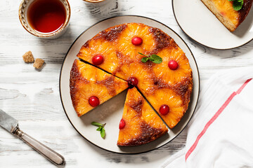 Homemade pineapple upside down pie with candied cranberry . Tropical dessert on white wooden...