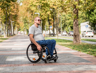 Handicapped man in wheelchair walk at the park alley