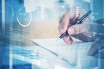 Man taking notes in office and graphs