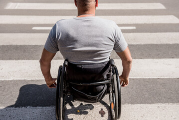 Handicapped man in wheelchair crossing street road