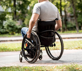 Obraz premium Handicapped man in wheelchair walk at the park alley