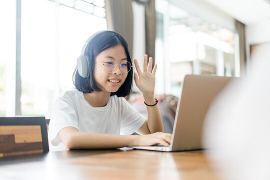 Asian Pre Teens Girl Study Online Learning In Class.online Education. Video Call With Zoom , Happy Asian Girl Chat With Friends And Teacher.online With Laptop Lockdown At Home.Covid-19 Coronavirus.