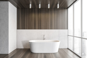 Fototapeta na wymiar White bathtub on wooden floor in bathroom near window, white wooden design