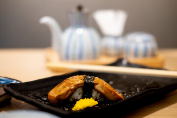 Foie gras sushi on the rectangular black ceramic plate.