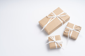 Obraz premium Brown gift box tied with white ribbon on clear background