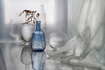 Still life of glass objects on a transparent surface near the window