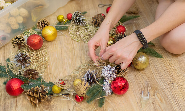 An unrecognizable caucasian girl is making of Christmas decorations.

