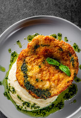 schnitzel with mashed potatoes and pesto sauce on plate