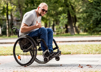 Obraz premium Handicapped man in wheelchair walk at the park alley