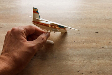 Scale model  of a two-engined passenger plane and a male hand that wants to take it. Toy. 