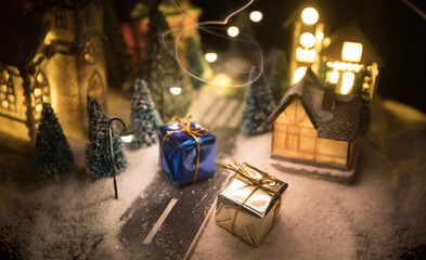 New Year miniature house in the snow at night with fir tree. Holiday concept. Selective focus