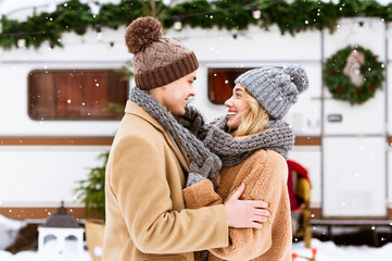 Warming Love. Happy Young Couple Cuddling Under Falling Snow, Covering With Scarf