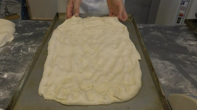 Laboratorio di una panetteria con fornaio che prepara il pane in maniera artigianale