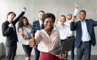 African Businesswoman Gesturing Thumbs-Up Standing With Colleagues In Office
