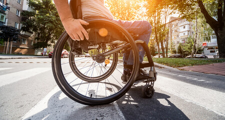Handicapped man in wheelchair crossing street road