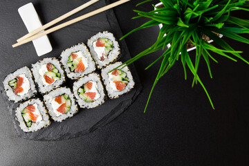 Sushi rolls with sesame seeds on a stone Board for sushi