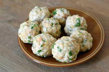 Hausgemachte Semmelknödel mit Petersilie auf dem Teller.