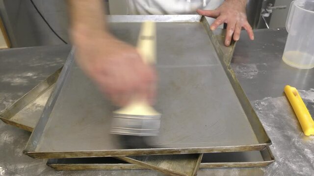 Laboratorio di una panetteria con fornaio che prepara il pane in maniera artigianale