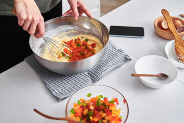 Woman in kitchen cooking a cake. Hands beat the dough with mixer