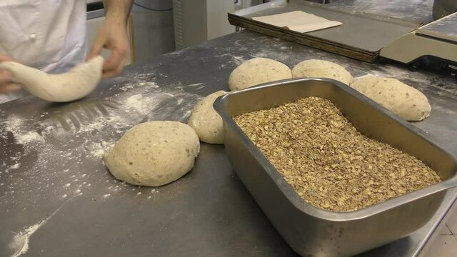Laboratorio di una panetteria con fornaio che prepara il pane in maniera artigianale