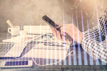 Fototapeta premium Double exposure of man's hands holding and using a digital device and forex graph drawing. Financial market concept.