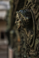 Fototapeta na wymiar Sculpture de femme de profil sur une grille