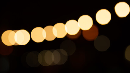 Abstract evening night shimmering bokeh background effect street outside near cafe restaurant. Defocused urban city life blur golden light bulbs garlands. Christmas New Year party holiday concept. 